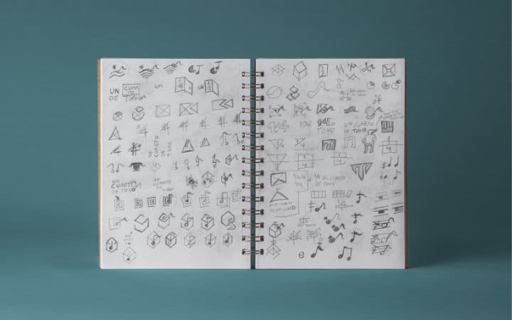 Sketches of logos and graphic elements for Cuarto de Tono in a notebook.