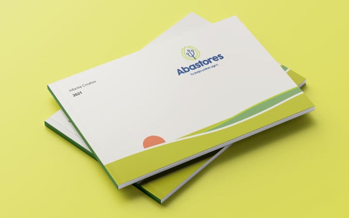 El informe creativo de Abastores en el que aparece en su portada su amanecer simbólico hecho en gráficos vectoriales planos con un campo verde en varios tonos y el sol rojo del amanecer.